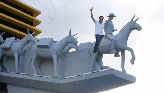 Monumento do sesquicentário de CG com pessoa montando burro